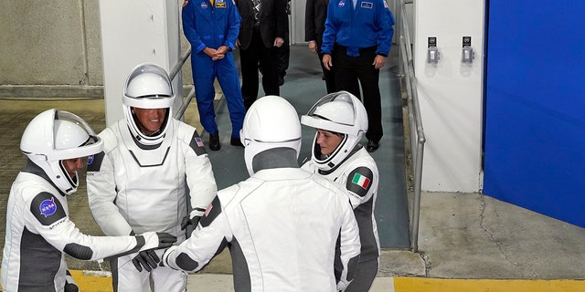 SpaceX Crew-4 astronotları, solda, görev uzmanı Jessica Watkins, pilot Bob Hines, Komutan Kjell Lindgren ve İtalya'dan görev uzmanı ESA astronotu Samantha Cristoforetti, fırlatma kompleksine bir uçuş için operasyon binasından ve itiş gücünden ayrıldıktan sonra bir araya geliyor. 27 Nisan 2022 Çarşamba, Florida, Cape Canaveral'daki Kennedy Uzay Merkezi'nde.