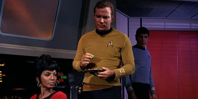 Nichelle Nichols (solda, Uhura olarak) ve William Shatner (Kaptan James T. Kirk olarak) USS Enterprise köprüsünde "adam tuzağı" ilk bölümü "Yıldız Savaşları," 8 Eylül 1966'da yayınlandı.